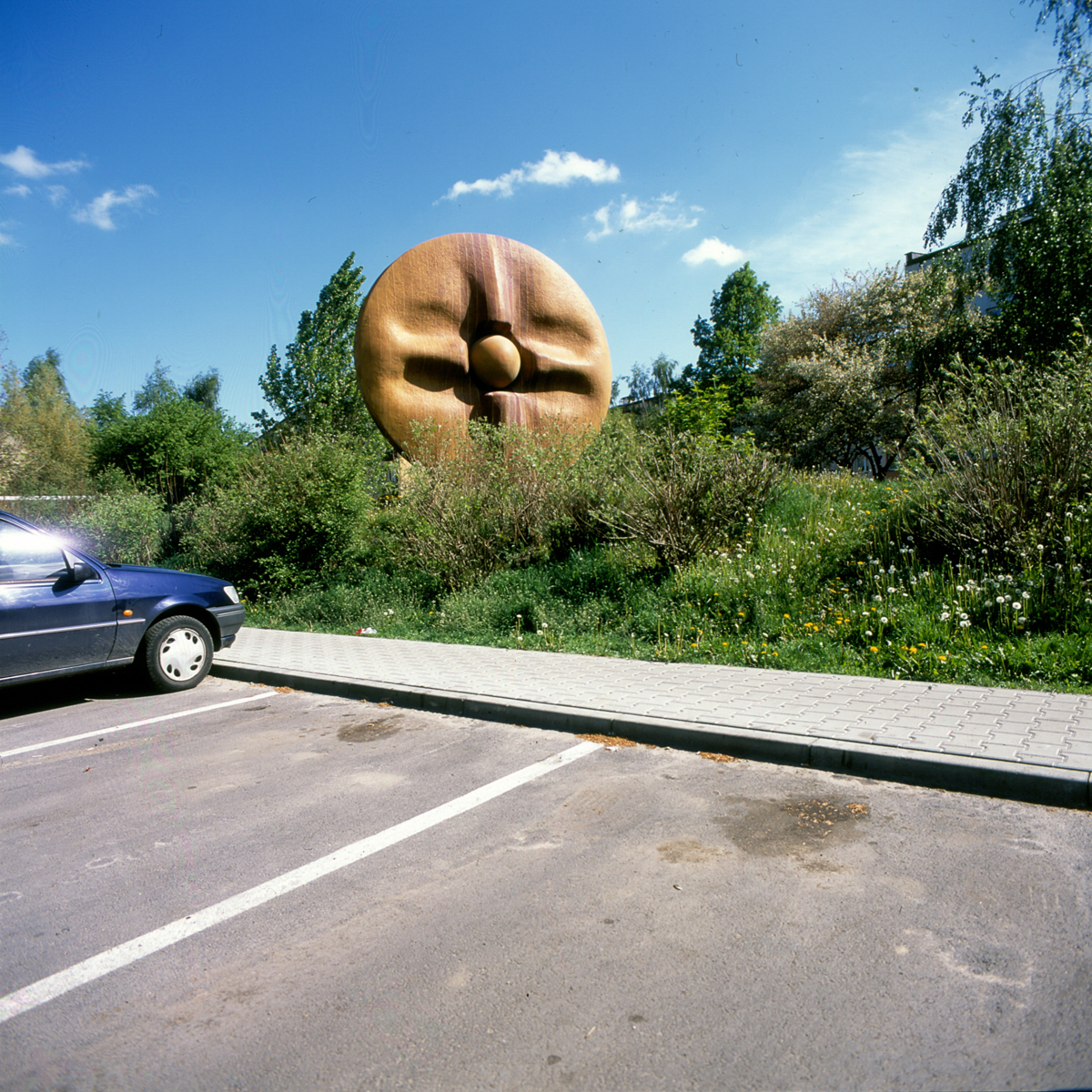 Fotografia współczesna z 2015 r. przestawiająca pagórek z rzeźbą na Osiedlu Słonecznym w Ostrowcu. Na pierwszym