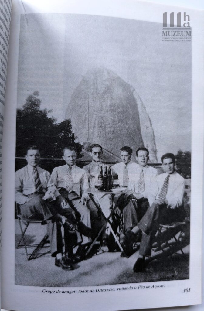 Grupa 6 mężczyzn siedzi przy stole, w tle góra w Brazylii